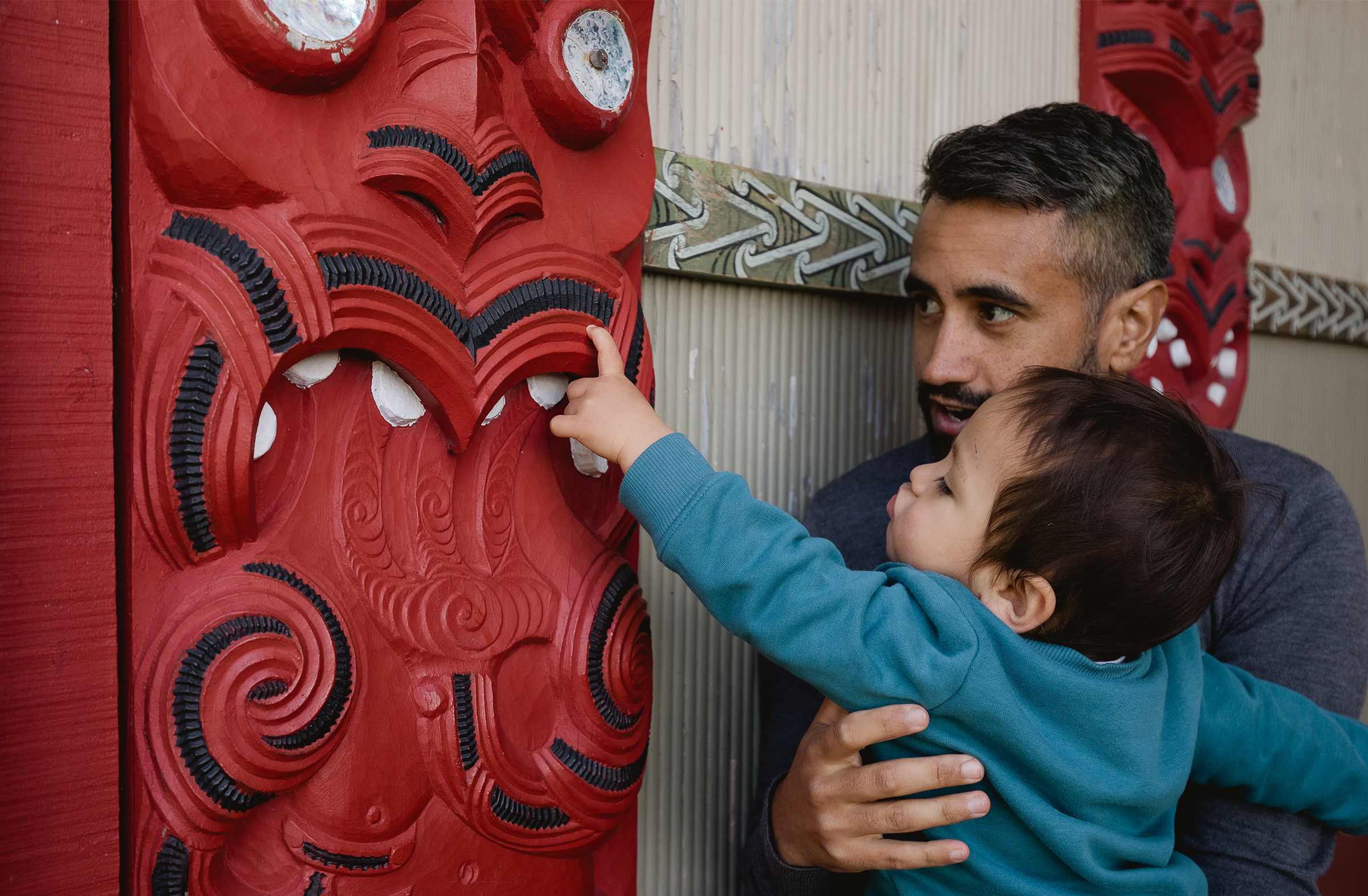 father holding child at marae